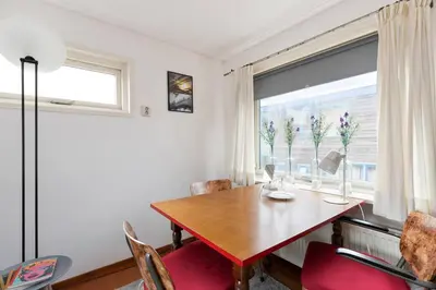 a dining room with a wooden table and a window at Authentic Dutch Houseboat in Amsterdam Zuid in Amsterdam
