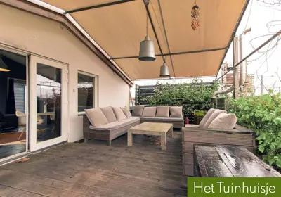 a patio with couches and a table on a deck at Garden House, Private studio apartment with wifi and free parking for 1 car in Weesp
