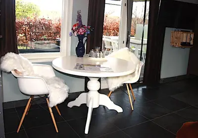 a white table and chairs in a room with a window at Garden House, Private studio apartment with wifi and free parking for 1 car in Weesp