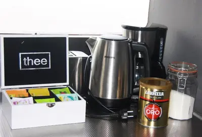 a coffee maker and a box on a table at Garden House, Private studio apartment with wifi and free parking for 1 car in Weesp