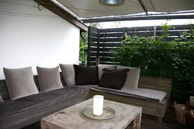 a couch sitting on a patio with a table at Garden House, Private studio apartment with wifi and free parking for 1 car in Weesp