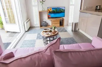 a living room with a purple couch and a tv at B&B Bike Studio Amsterdam in Amsterdam