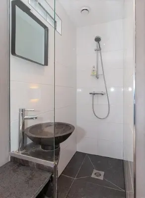 a bathroom with a sink and a glass shower at B&B Bike Studio Amsterdam in Amsterdam