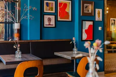 two tables in a restaurant with blue walls at Hotel van de Vijsel in Amsterdam