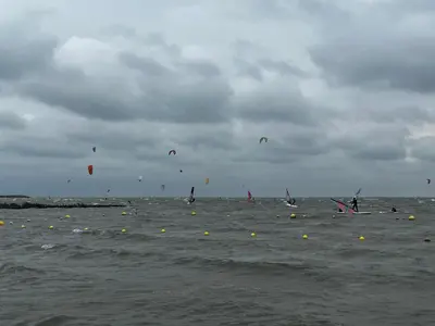 a group of people flying kites in the water at Vakantiehuis Het Uilennest in Wijdenes