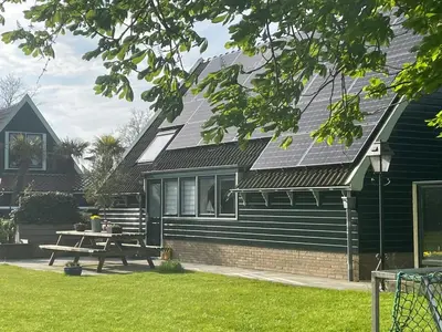a house with a picnic table in front of it at Vakantiehuis Het Uilennest in Wijdenes