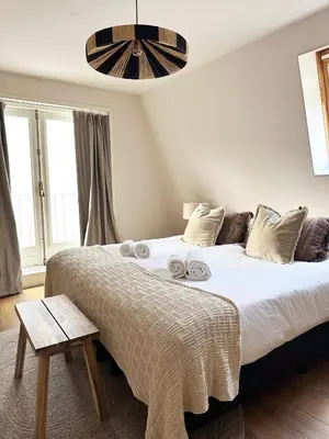 a bedroom with a large bed with white sheets at Rembrandtplein Apartments in Amsterdam