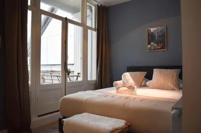 a bedroom with a large bed and a large window at Rembrandtplein Apartments in Amsterdam