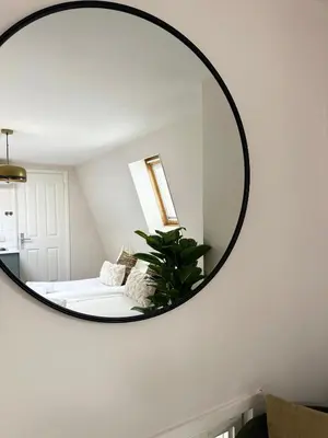 a mirror hanging on a wall in a bedroom at Rembrandtplein Apartments in Amsterdam