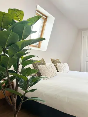 a bedroom with a bed with a plant next to it at Rembrandtplein Apartments in Amsterdam