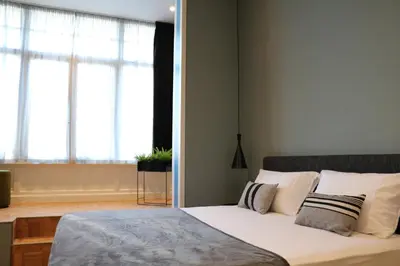 a bedroom with a bed with white sheets and pillows at Quentin Zoo Hotel in Amsterdam