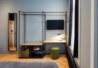 a bedroom with a desk and a glass wall at Quentin Zoo Hotel in Amsterdam
