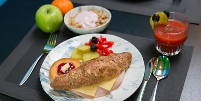 a plate of food with meat and fruit on a table at Quentin Zoo Hotel in Amsterdam