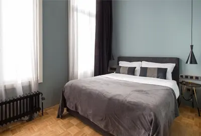a bedroom with a large bed and windows at Quentin Zoo Hotel in Amsterdam