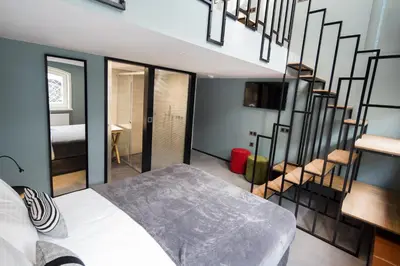 a bedroom with a bed and a spiral staircase at Quentin Zoo Hotel in Amsterdam