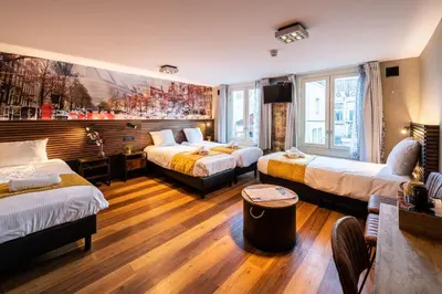 a hotel room with three beds and a couch at Historic Centre Hotel in Amsterdam