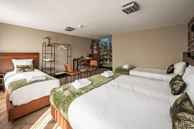 a hotel room with two beds and a table at Historic Centre Hotel in Amsterdam