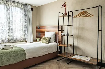 a bedroom with a bed and a book shelf at Historic Centre Hotel in Amsterdam