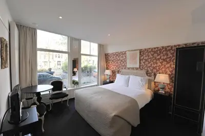 a hotel room with a bed and a window at The Posthoorn Amsterdam in Amsterdam