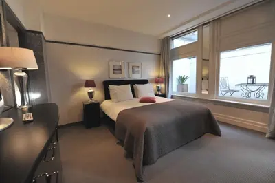 a bedroom with a bed and a large window at The Posthoorn Amsterdam in Amsterdam