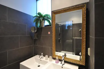 a bathroom with a sink and a mirror at The Posthoorn Amsterdam in Amsterdam