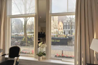a window with a view of a city at The Posthoorn Amsterdam in Amsterdam