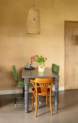 a table with chairs and a vase with flowers on it at Boerenhofstede de Overhorn in Weesp