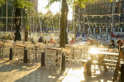 a group of people sitting at tables in a patio at The Water Studio in Amsterdam