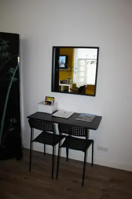a desk with two chairs and a mirror on a wall at The Water Studio in Amsterdam