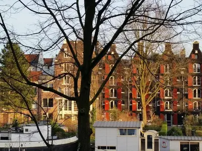 a tree with a white garage in front of a building at Central & Quiet Canal Apartment in Amsterdam