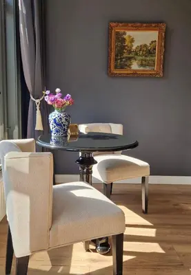a table with chairs and a vase with flowers on it at Canal House The Tannery Amsterdam in Amsterdam