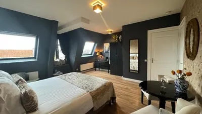 a bedroom with blue walls and a bed and a table at Canal House The Tannery Amsterdam in Amsterdam