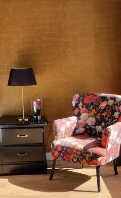 a bedroom with a chair and a lamp and a dresser at Canal House The Tannery Amsterdam in Amsterdam