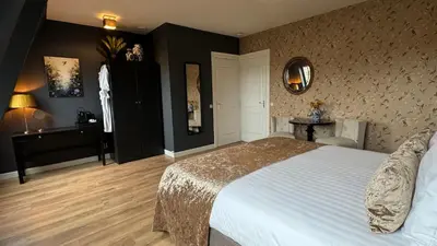 a bedroom with a bed and a table and a mirror at Canal House The Tannery Amsterdam in Amsterdam