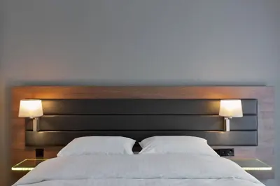a bedroom with a large bed with two lamps at Moxy Amsterdam Houthavens in Amsterdam