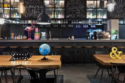 a bar with a wooden table with a globe on it at Moxy Amsterdam Houthavens in Amsterdam