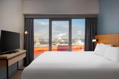 a hotel room with a large bed and a large window at Residence Inn by Marriott Amsterdam Houthavens in Amsterdam
