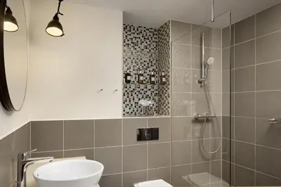 a bathroom with a shower and a toilet and a sink at Residence Inn by Marriott Amsterdam Houthavens in Amsterdam
