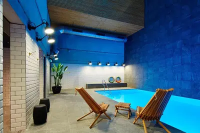 a swimming pool with two chairs and a swimming pool at Residence Inn by Marriott Amsterdam Houthavens in Amsterdam