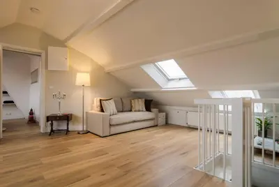 a living room with a couch and a window at Beautiful penthouse near Rai and centre in Amsterdam