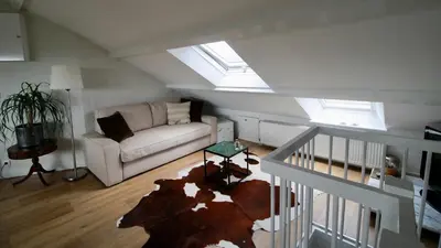 a living room with a couch and some windows at Beautiful penthouse near Rai and centre in Amsterdam