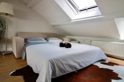 a bedroom with a large white bed with a window at Beautiful penthouse near Rai and centre in Amsterdam