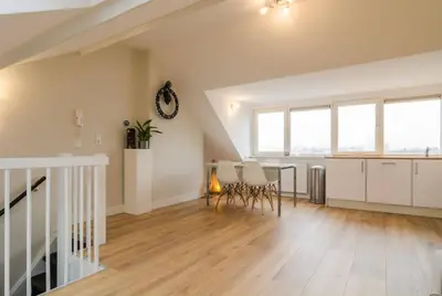 an attic living room with a table and chairs at Beautiful penthouse near Rai and centre in Amsterdam