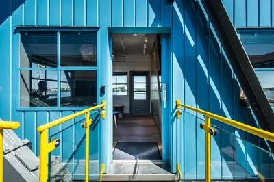 an open door of a blue building with yellow rails at Numa Amsterdam The Crane in Amsterdam