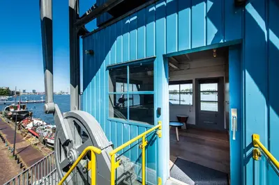 a blue boat with a door and a balcony at Numa Amsterdam The Crane in Amsterdam