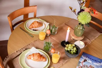a table with plates of croissants and orange juice at Wijngaard Saalhof in Wognum