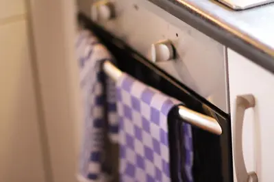 a row of towels hanging on an oven door at Wijngaard Saalhof in Wognum