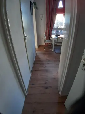 a hallway with a room with a table and a window at Appartementen Zandvoort in Zandvoort