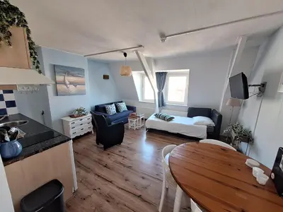 a kitchen and living room with a table and a couch at Appartementen Zandvoort in Zandvoort