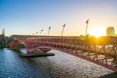 a bridge over a body of water with flags on it at Stylish Private Studio Close to City in Amsterdam